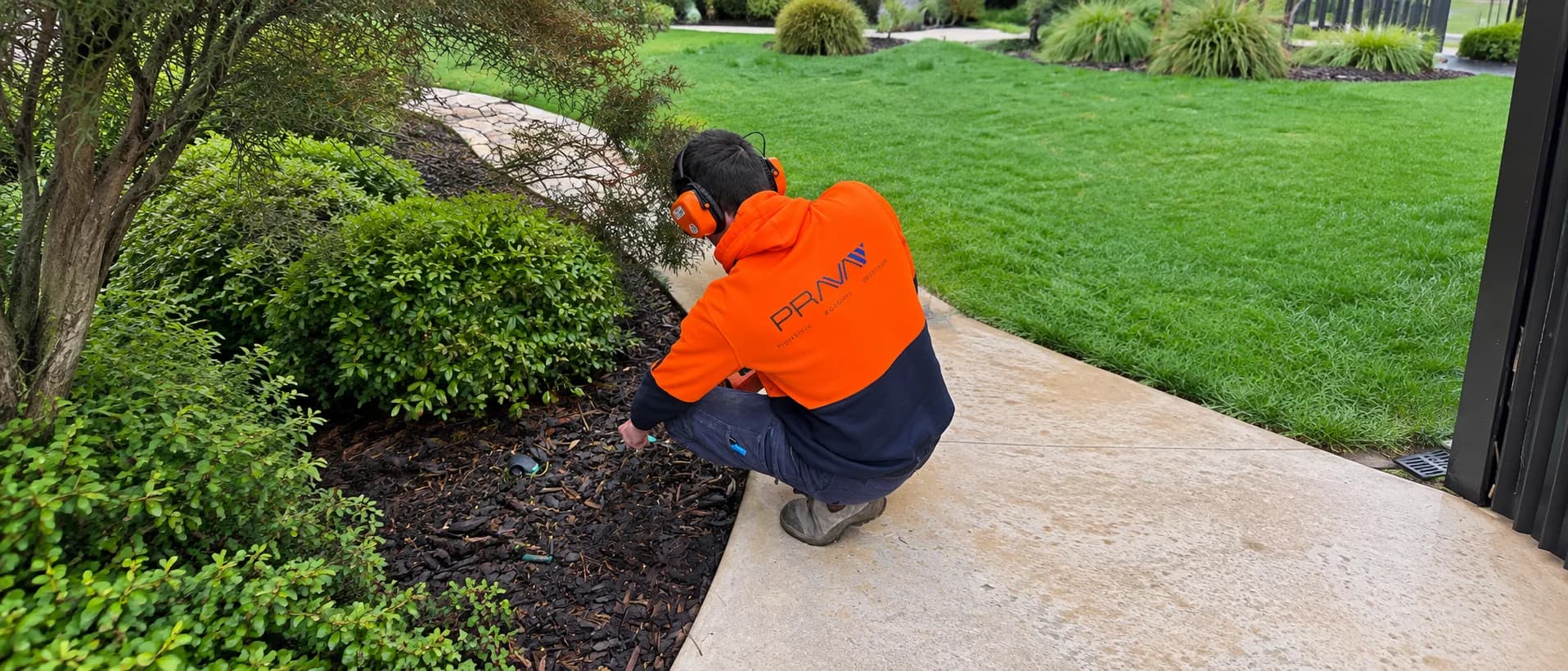 Prava technician inspecting a garden bed during a leak detection job